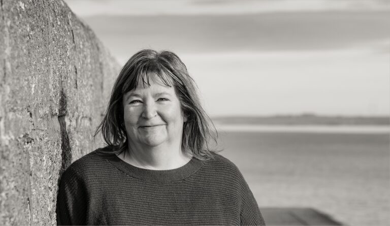 Anne standing by harbour wall